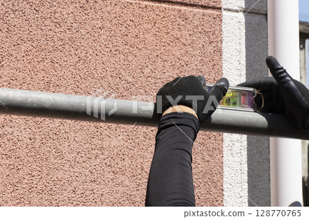Workers assembling scaffolding 128770765