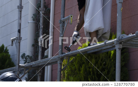 Workers assembling scaffolding Workers assembling scaffolding 128770780