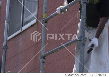 Workers assembling scaffolding Workers assembling scaffolding 128770781