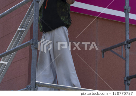 Workers assembling scaffolding Workers assembling scaffolding 128770787
