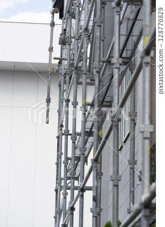 Workers assembling scaffolding Workers assembling scaffolding 128770829