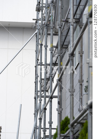 Workers assembling scaffolding Workers assembling scaffolding 128770830