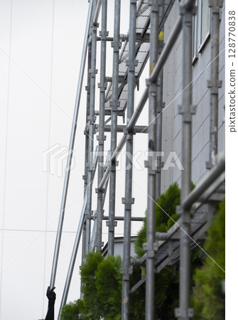 Workers assembling scaffolding Workers assembling scaffolding 128770838