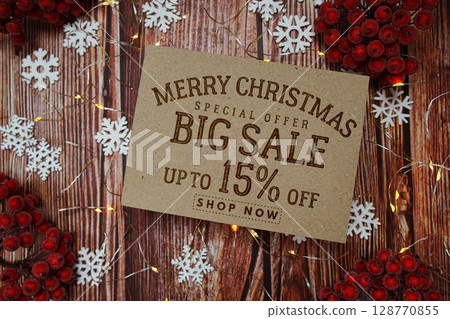 Merry Christmas Big Sale 15% text on paper card with Snowflake and LED light decoration on wooden background Merry Christmas Big Sale 15% text on paper card with Snowflake and LED light decoration on wooden background 128770855