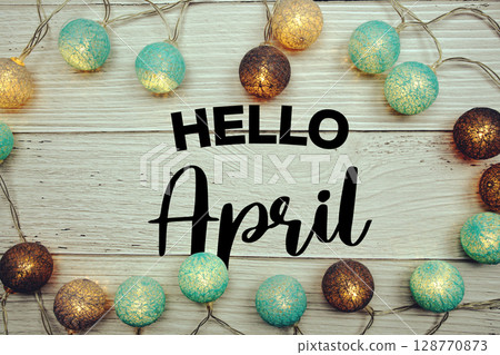 Hello April text with LED cotton balls decorated on wooden background 128770873
