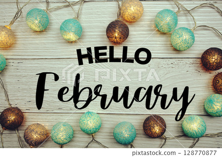 Hello February text with LED cotton balls decorated on wooden background 128770877