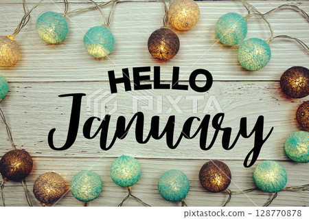 Hello January text with LED cotton balls decorated on wooden background 128770878