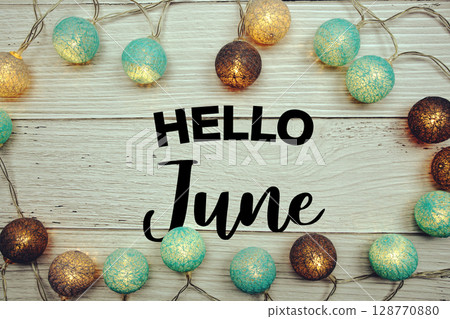 Hello June text with LED cotton balls decorated on wooden background Hello June text with LED cotton balls decorated on wooden background 128770880