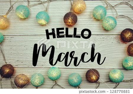 Hello March text with LED cotton balls decorated on wooden background 128770881