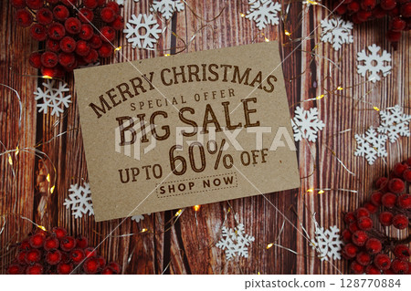 Merry Christmas Big Sale 60% text on paper card with Snowflake and LED light decoration on wooden background 128770884
