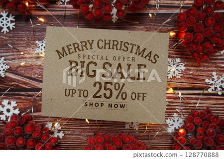 Merry Christmas Big Sale 25% text on paper card with Snowflake and LED light decoration on wooden background 128770888