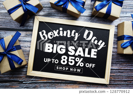 Boxing Day Big Sale 85% Off text on blackboard with present gifts on wooden background Boxing Day Big Sale 85% Off text on blackboard with present gifts on wooden background 128770912