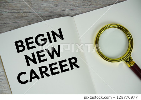 Begin New Career text message written on paper note with magnifying glass top view on wooden background 128770977