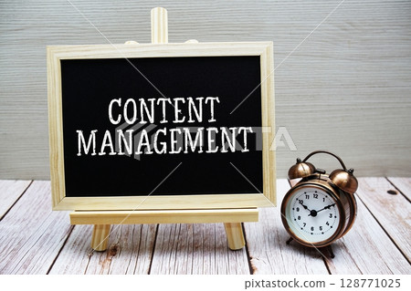 Content Management text written on chalkboard with alarm clock on wooden background 128771025