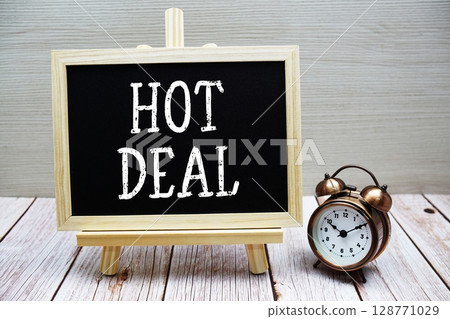 Hot Deal text written on chalkboard with alarm clock on wooden background 128771029
