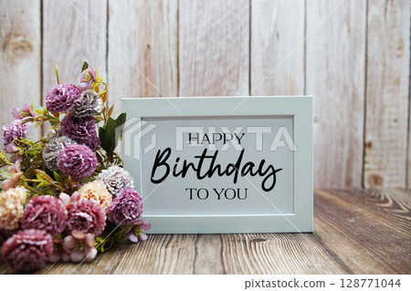 Happy Birthday To You text with flower decoration on wooden background Happy Birthday To You text with flower decoration on wooden background 128771044