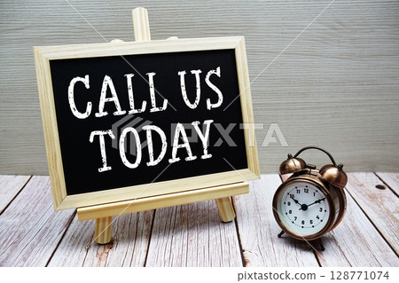 Call Us Today text written on chalkboard with alarm clock on wooden background Call Us Today text written on chalkboard with alarm clock on wooden background 128771074