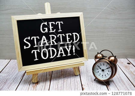 Get Started Today! text written on chalkboard with alarm clock on wooden background 128771078