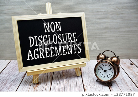 Non Disclosure Agreements text written on chalkboard with alarm clock on wooden background Non Disclosure Agreements text written on chalkboard with alarm clock on wooden background 128771087