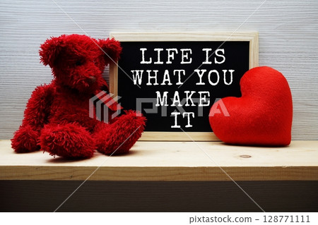 Life Is What You Make It Motivational and Inspiration Quotes on chalkboard with teddy bear on wooden background 128771111