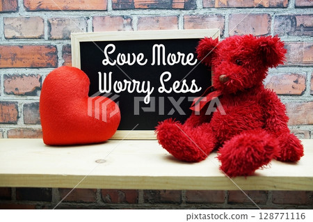 Love More Worry Less Motivational and Inspiration Quotes on chalkboard with teddy bear on wooden background 128771116