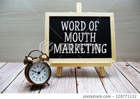 Word Of Mouth Marketing text written on chalkboard with alarm clock on wooden background Word Of Mouth Marketing text written on chalkboard with alarm clock on wooden background 128771132