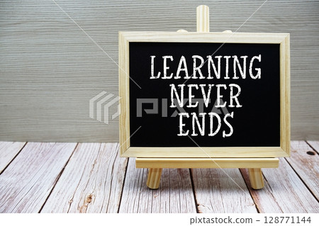 Learning Never Ends text written on chalkboard with easel on wooden background Learning Never Ends text written on chalkboard with easel on wooden background 128771144