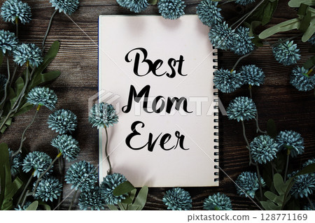 Best Mom Ever text with flowers decoration on wooden background 128771169