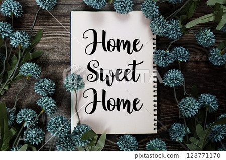 Home Sweet Home text with flowers decoration on wooden background 128771170