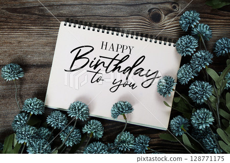 Happy Birthday to you text with flowers decoration on wooden background 128771175
