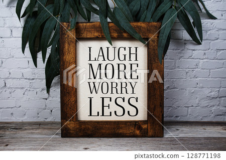 Laugh More Worry Less Motivational and Inspirational quotes on wooden background 128771198