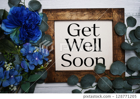 Get Well Soon text with flowers bouquet decoration on wooden background 128771205