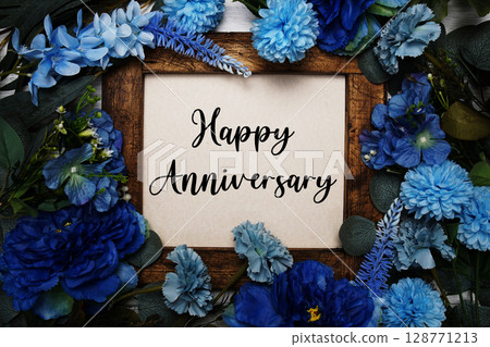 Happy Anniversary text with flowers bouquet decoration on wooden  background 128771213