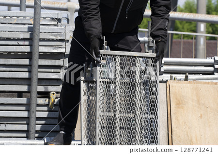搭建鷹架：工人從卡車上卸下材料並進行準備 128771241