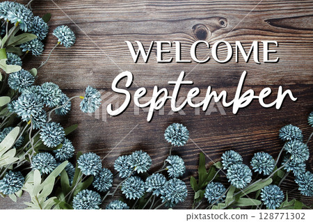 Welcome September text with flowers decoration on wooden background Welcome September text with flowers decoration on wooden background 128771302