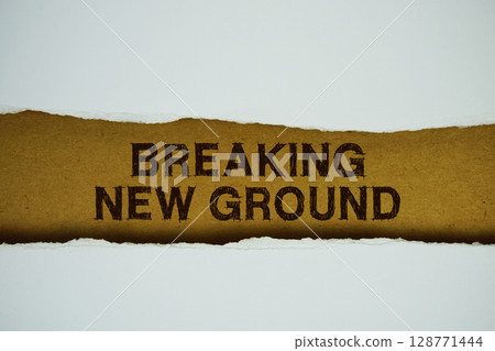 Breaking New Ground text on paper craft with white paper torn ripped of horizontal 128771444