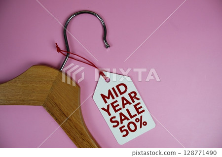 Mid Year Sale 50% off text on price tag label with Clothes hanger fashion shopping concept Mid Year Sale 50% off text on price tag label with Clothes hanger fashion shopping concept 128771490