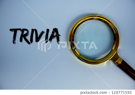 Trivia text with magnifying glass on blue background Trivia text with magnifying glass on blue background 128771592