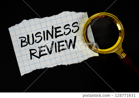 Business Review text written on paper with magnifying glass 128771631