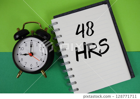 48 HRS text written on notebook paper with alarm clock 48 HRS text written on notebook paper with alarm clock 128771711