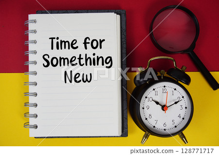 Time for Something New text written on notebook paper with magnifying glass and alarm clock Time for Something New text written on notebook paper with magnifying glass and alarm clock 128771717