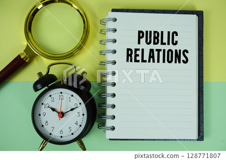 Public Relations text written on notebook paper with magnifying glass and alarm clock 128771807