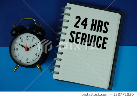 24 Hrs Service text written on notebook paper with alarm clock 128771820