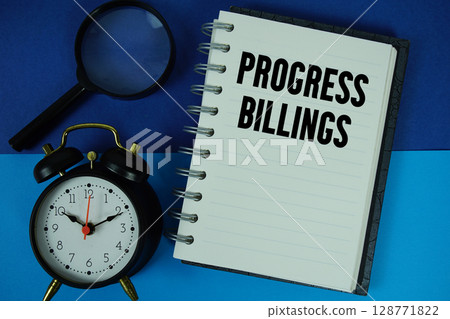 Progress Billings text written on notebook paper with alarm clock 128771822