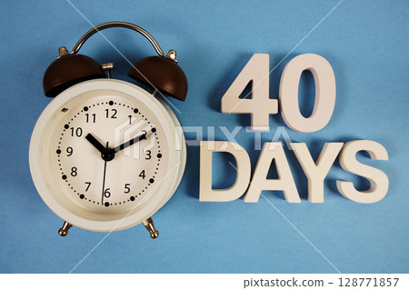 40 Days alphabet letters with alarm clock on blue background 128771857