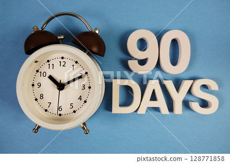 90 Days alphabet letters with alarm clock on blue background 128771858