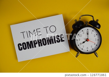 Time to Compromise alphabet letters with alarm clock flat lay on yellow background 128771861