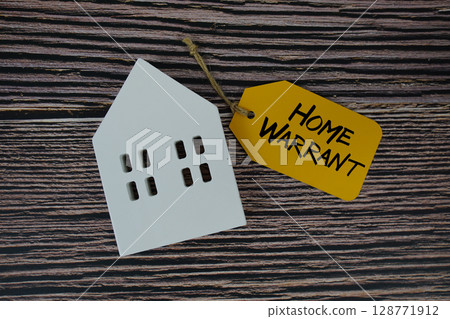 Home Warrant text on price tag with white house model flat lay on wooden background Home Warrant text on price tag with white house model flat lay on wooden background 128771912