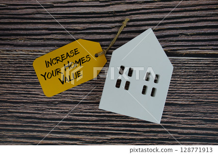Increase Your Homes Value text on price tag with white house model flat lay on wooden background Increase Your Homes Value text on price tag with white house model flat lay on wooden background 128771913