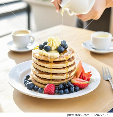 The moment maple syrup is poured onto delicious pancakes topped with cream The moment maple syrup is poured onto delicious pancakes topped with cream 128773259